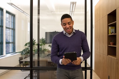 a man standing in an office looking at a tablet