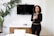 a woman standing in front of a flat screen tv