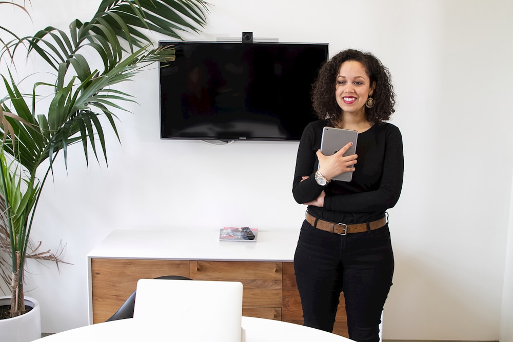 a woman standing in front of a flat screen tv