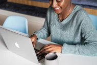 a woman sitting at a table using a laptop computer