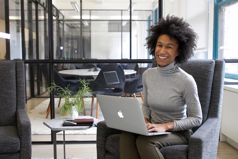 a woman sitting in a chair with a laptop