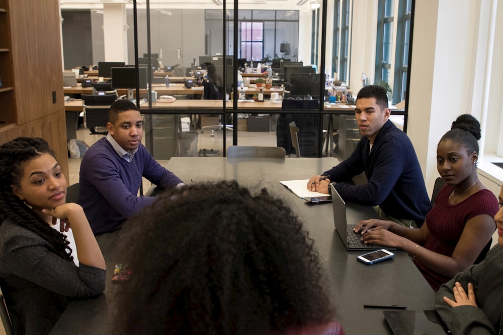 un groupe de personnes assises autour d’une table