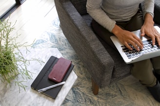 a woman sitting on a couch using a laptop computer