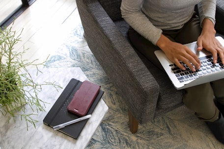 a woman sitting on a couch using a laptop computer
