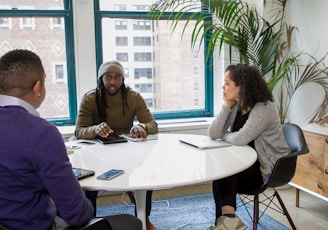 a group of people sitting around a white table