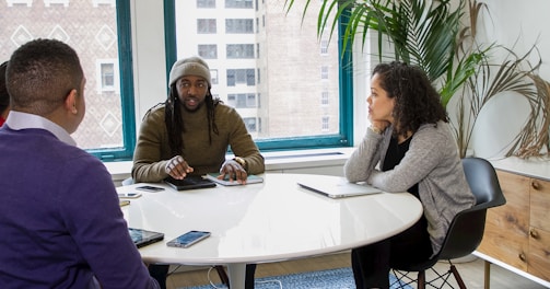 a group of people sitting around a white table