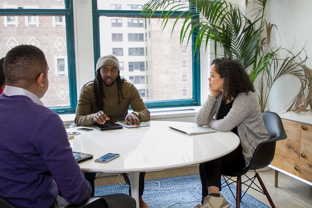 a group of people sitting around a white table