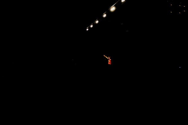 A dimly lit stage with a lone actor performing an intense scene from Trillionairing.