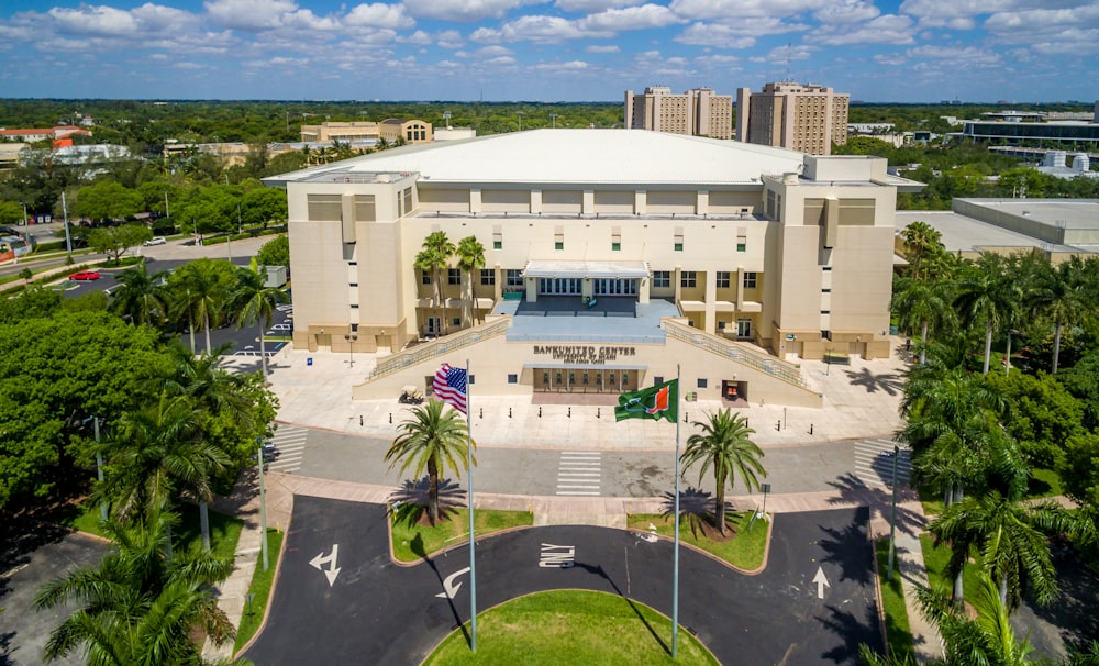 an aerial view of a large building surrounded by palm trees