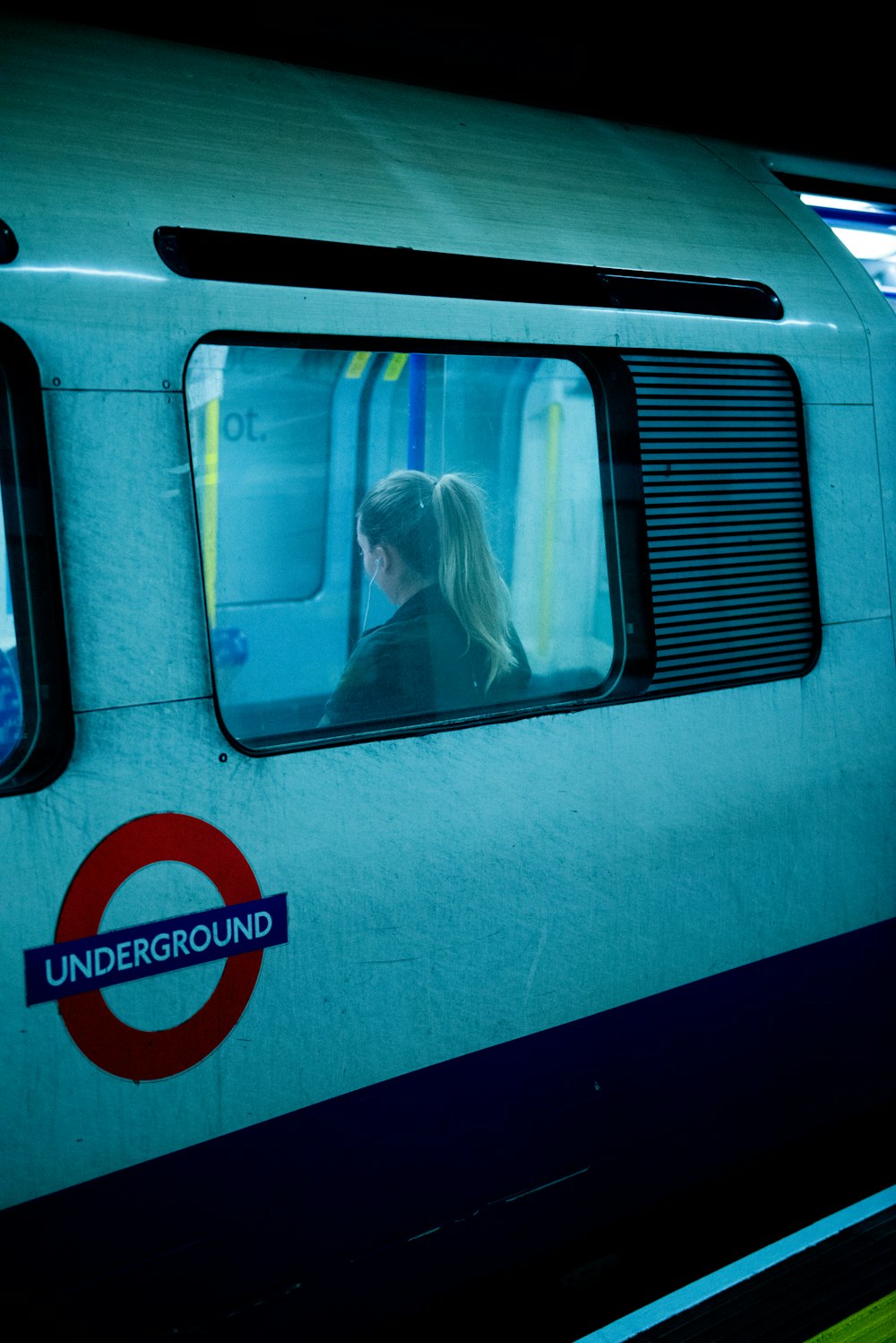 a woman sitting in a train looking out the window