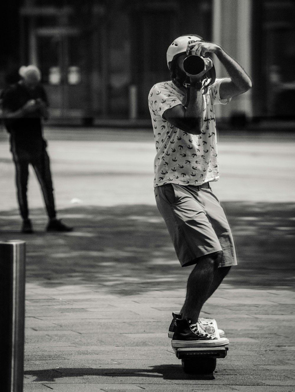 a man riding a skateboard while holding a camera