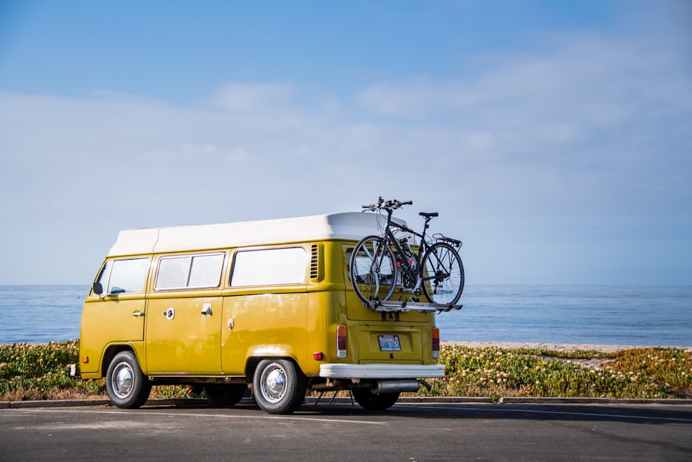 uma van amarela com uma bicicleta em cima dela