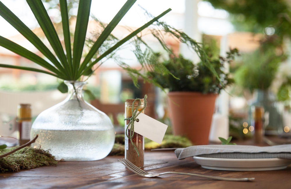 a wooden table topped with a vase filled with plants