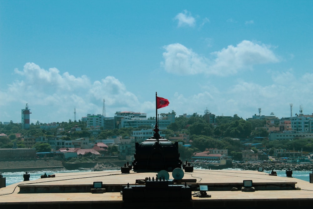 a flag on top of a building with a body of water in the background