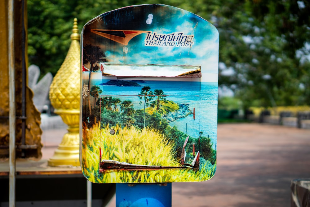 a mailbox with a picture of a landscape painted on it