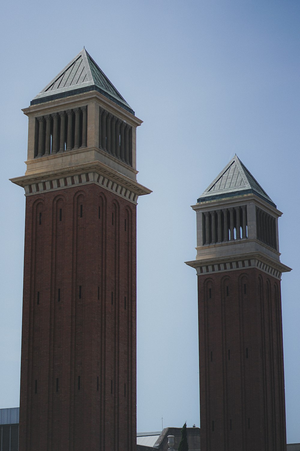 two tall brick towers with a clock on each of them