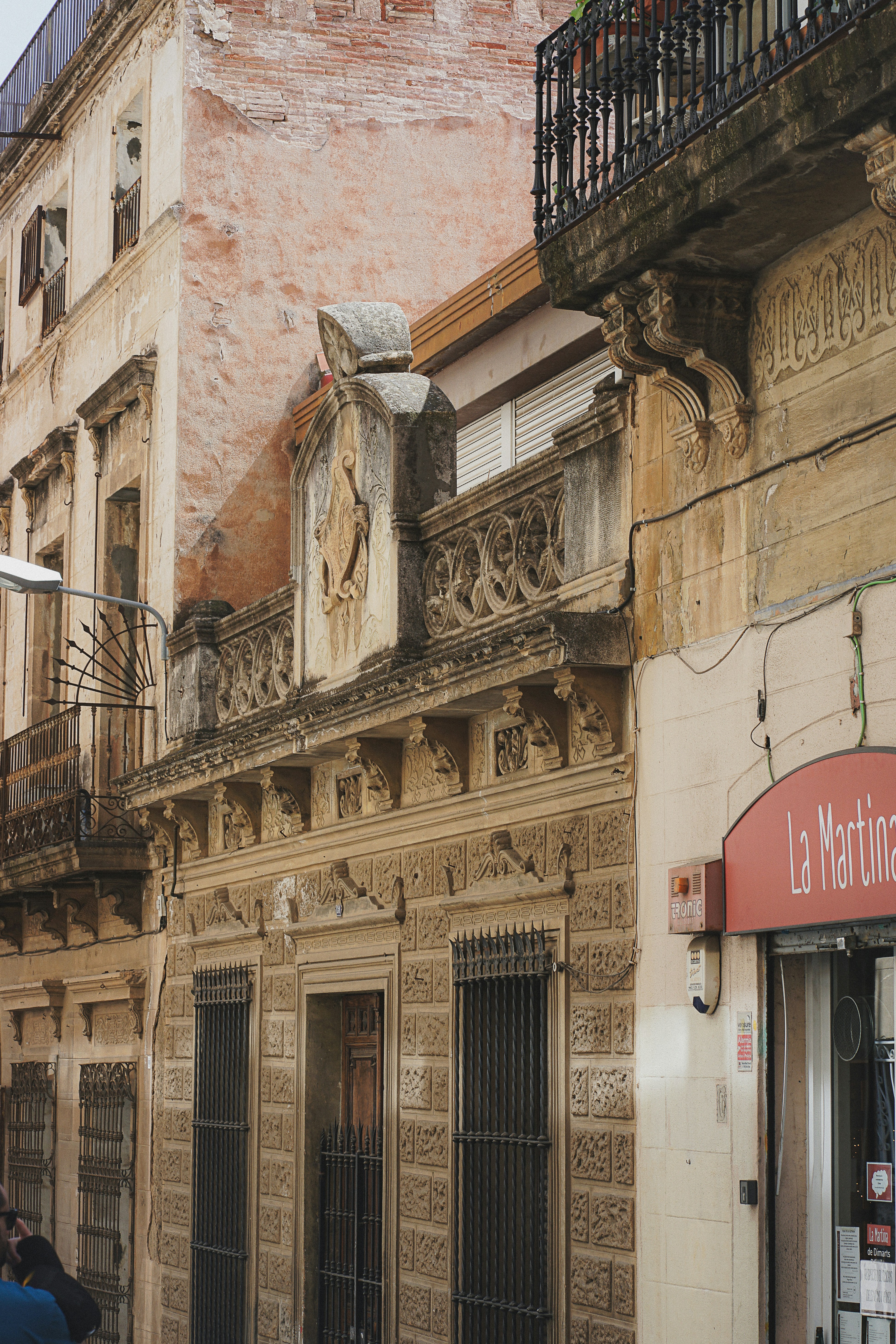 a couple of people walking down a street next to a tall building