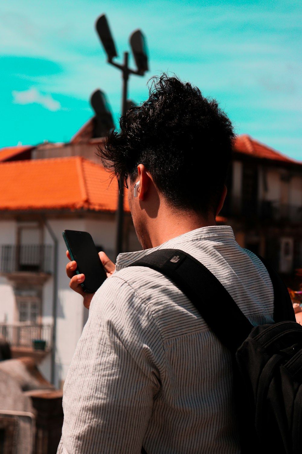 a man with a backpack looking at a cell phone