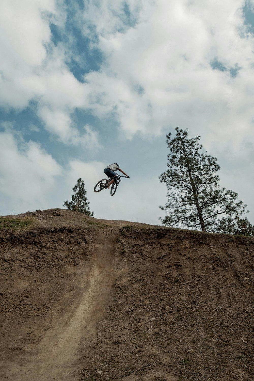 a man riding a bike up the side of a dirt hill