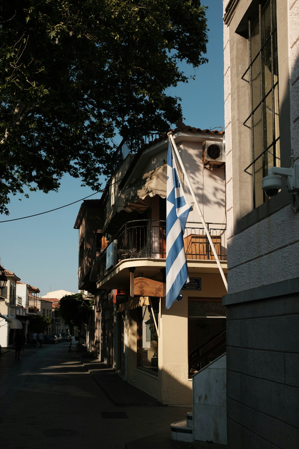 a blue and white flag hanging from the side of a building