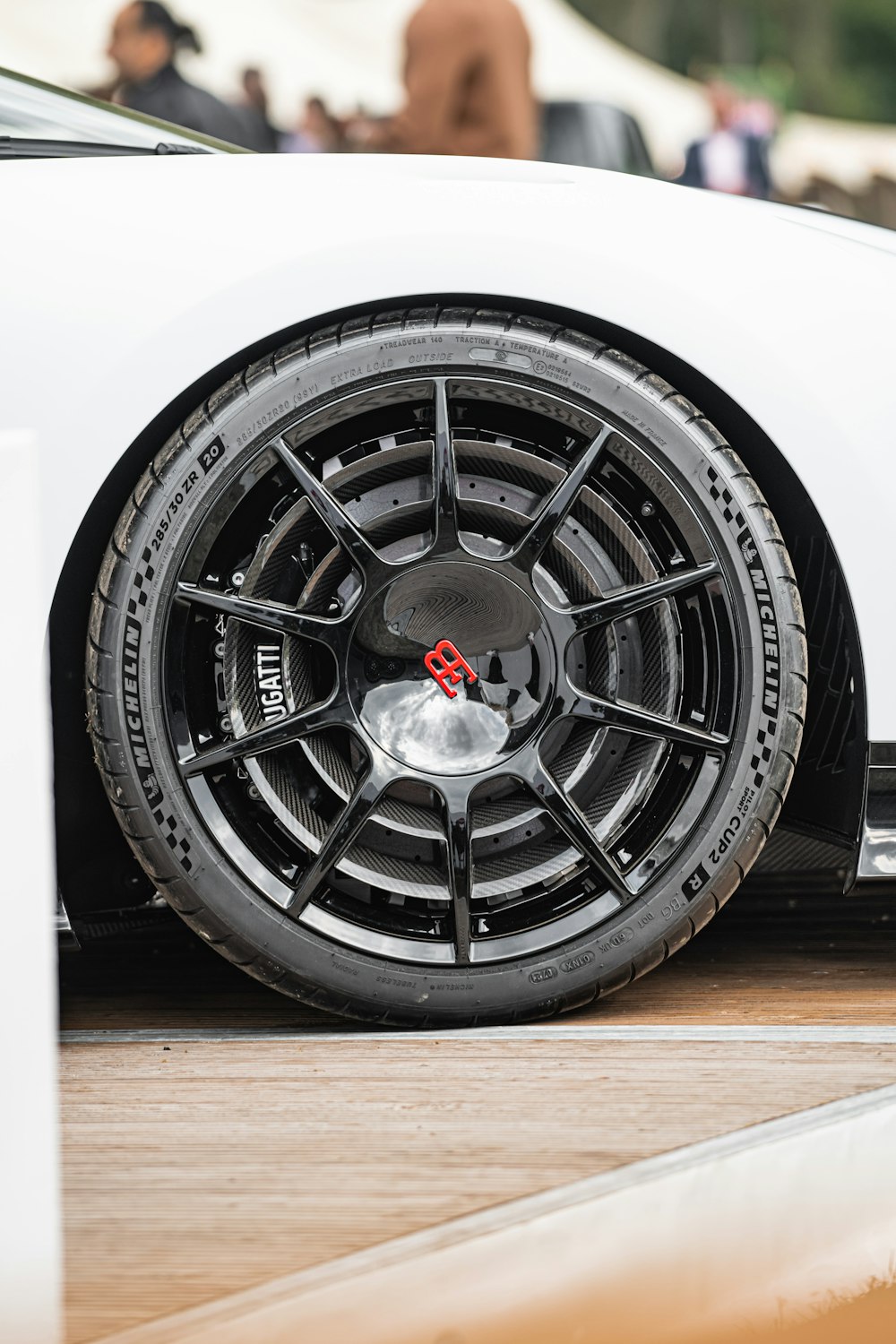 a close up of a white sports car on a wooden floor