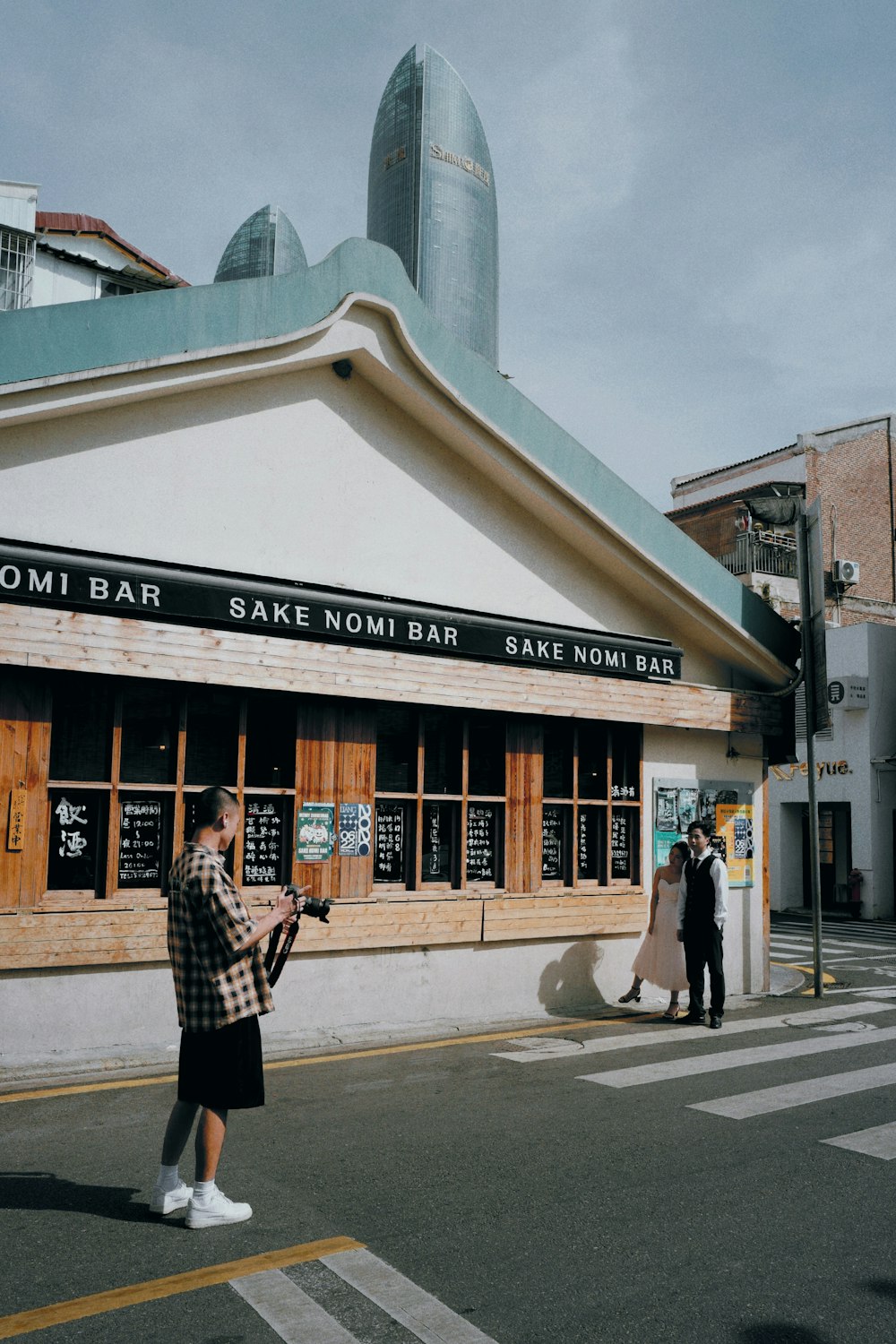 a man standing on the side of a road next to a building