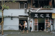 A small local business storefront with clear signage and customers.