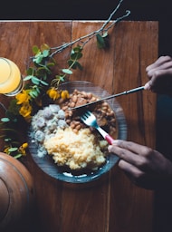 a plate of food on a table with a glass of orange juice