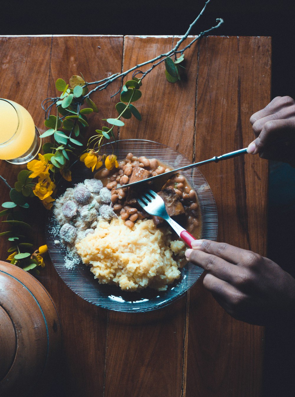 a plate of food on a table with a glass of orange juice