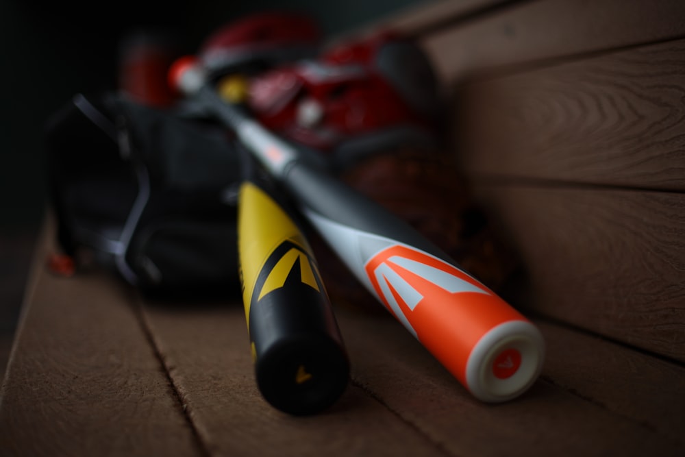 Un bate de béisbol y una bolsa sentados en un banco