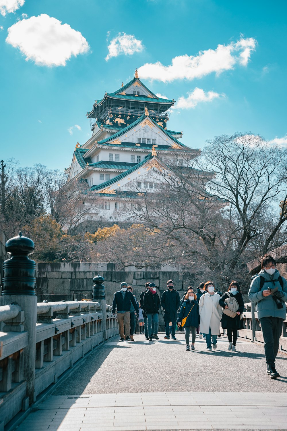 a group of people walking across a bridge