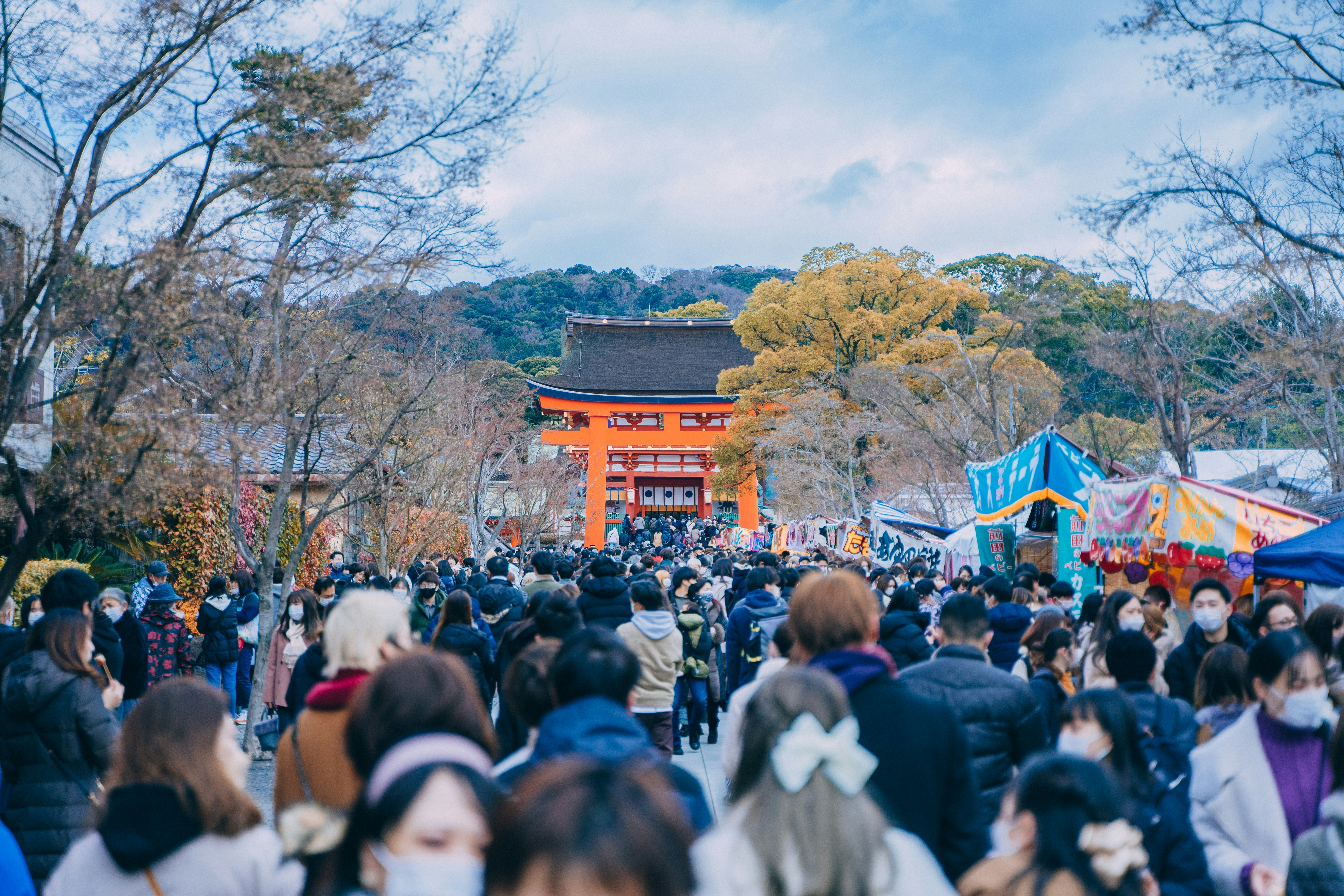 a crowd of people walking around a park, Fushimi Inari Shrine during December Holiday