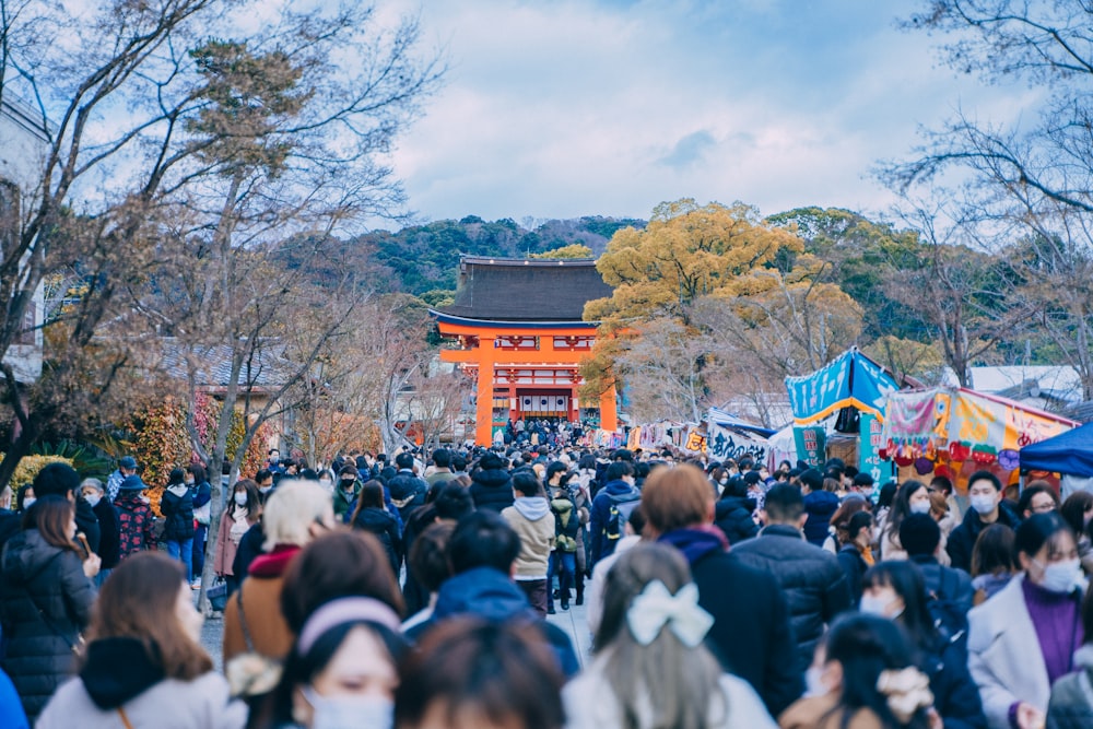 a crowd of people walking around a park