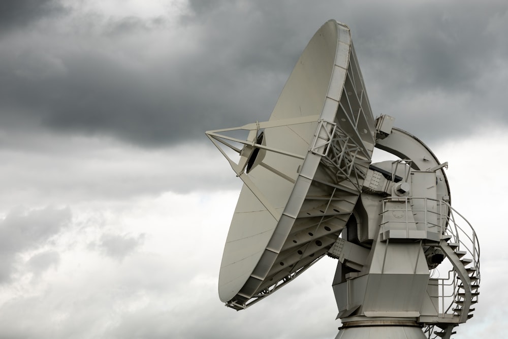 a large satellite dish sitting on top of a metal pole