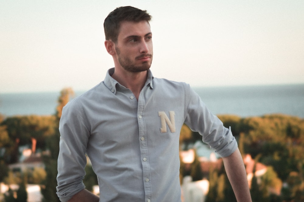 a man standing in front of a body of water