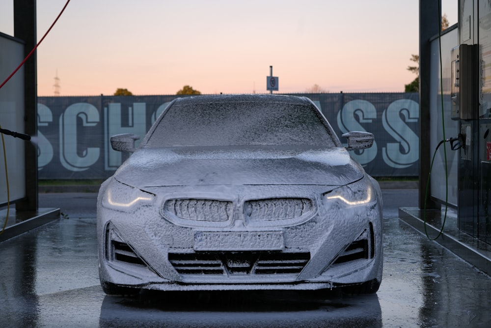 a car is covered in snow in front of a building