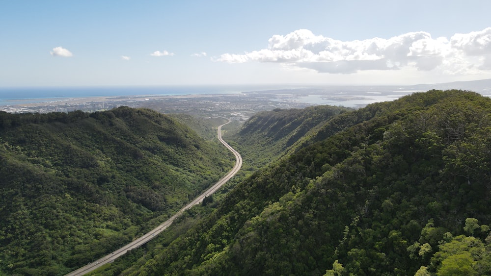 a winding road in the middle of a lush green valley