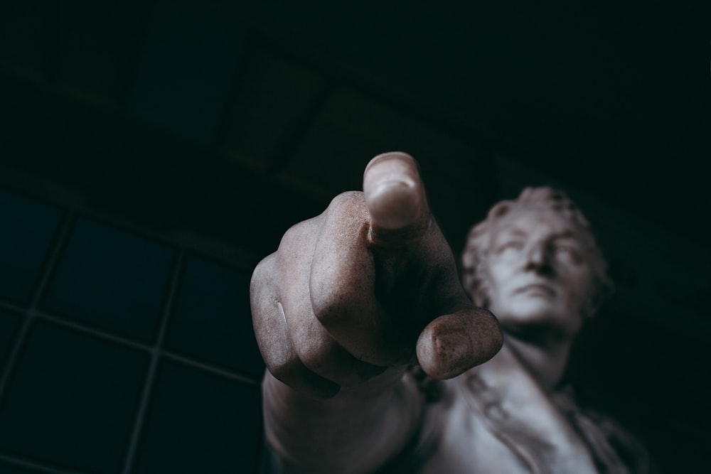 a statue of a man pointing at the camera