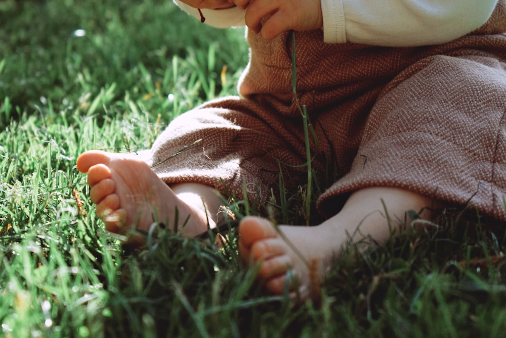 a small child sitting in the grass with a frisbee