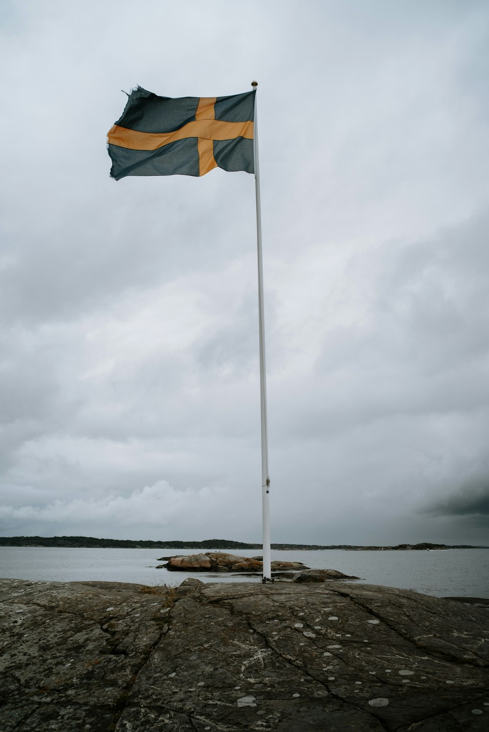 a flag on a rock by the water