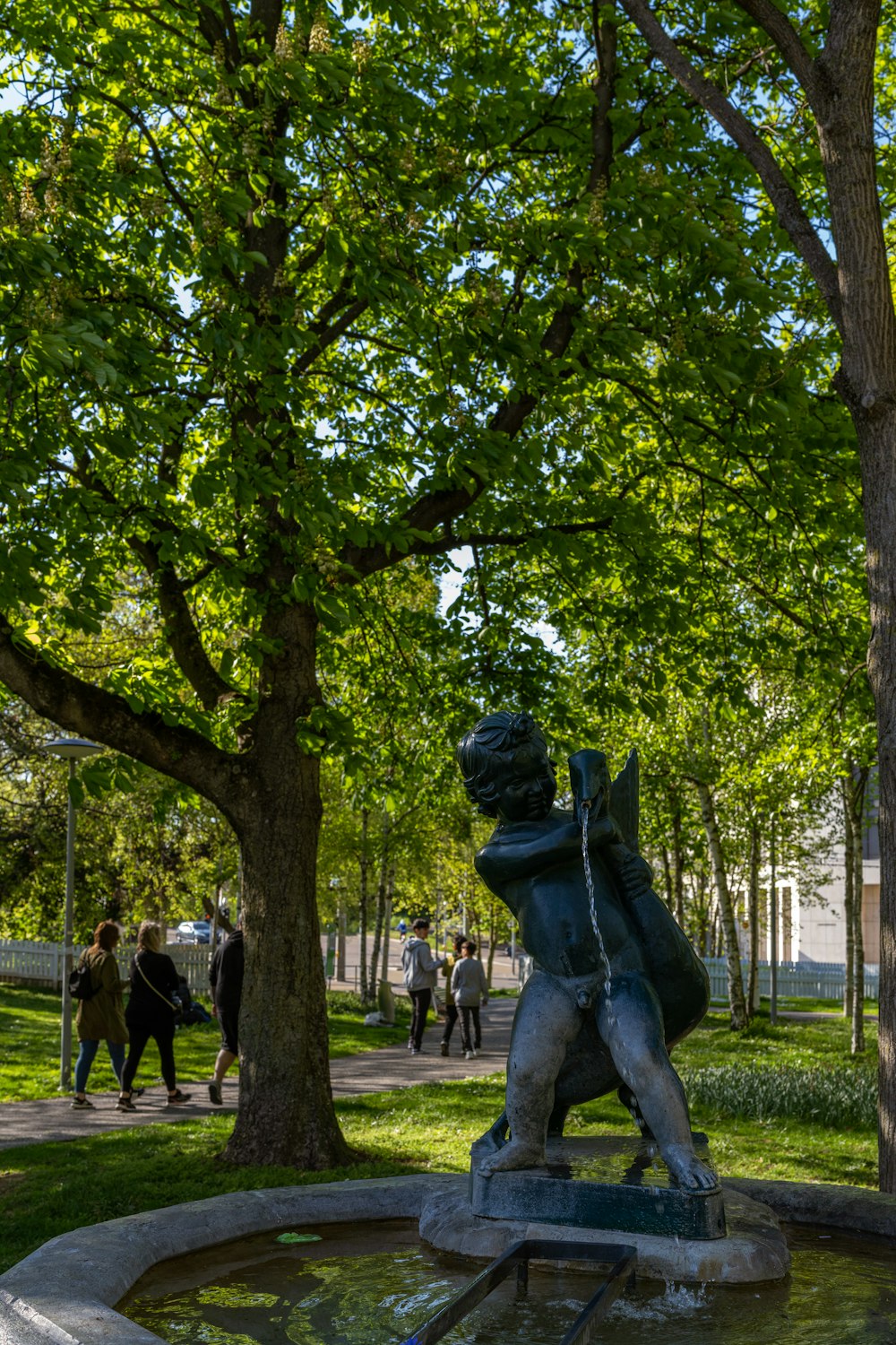 Una statua di un ragazzo è nel mezzo di un parco