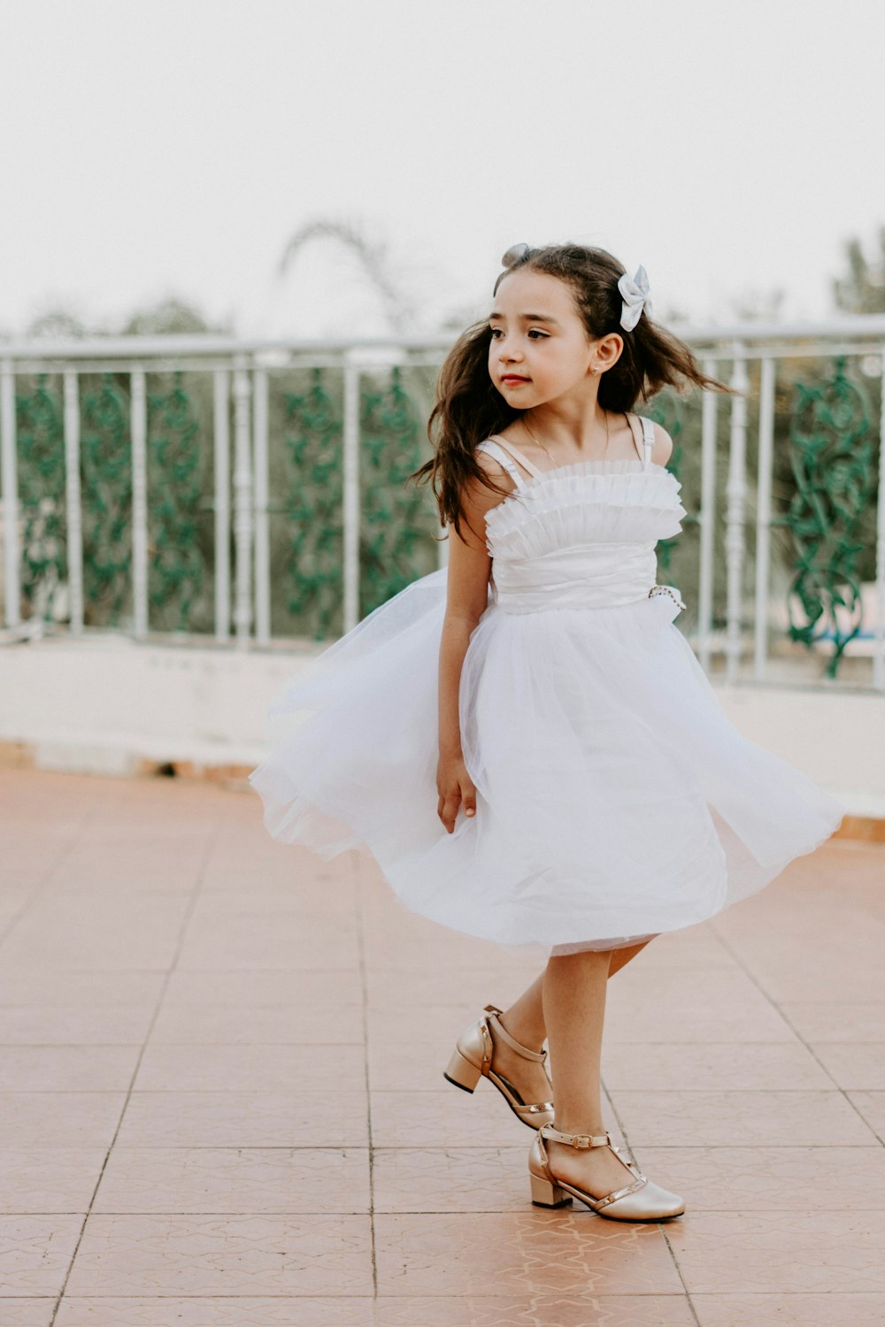 a little girl in a white dress is dancing