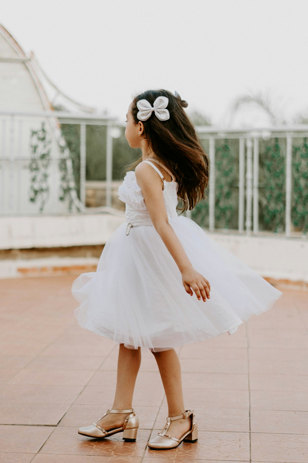 a little girl in a white dress and gold shoes photo – Free Morocco Image on  Unsplash