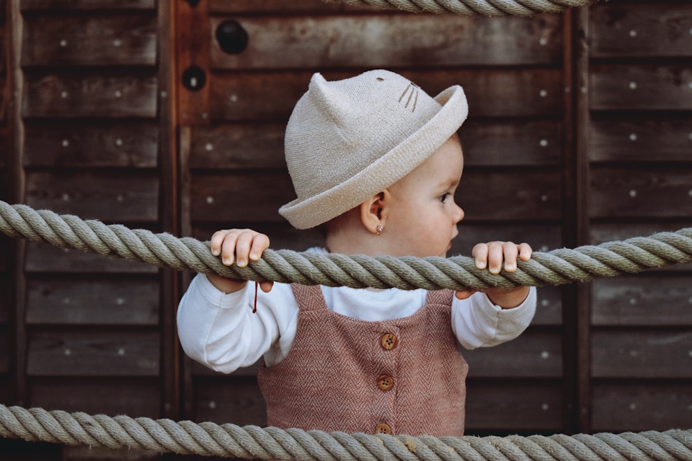 a small child is holding on to a rope