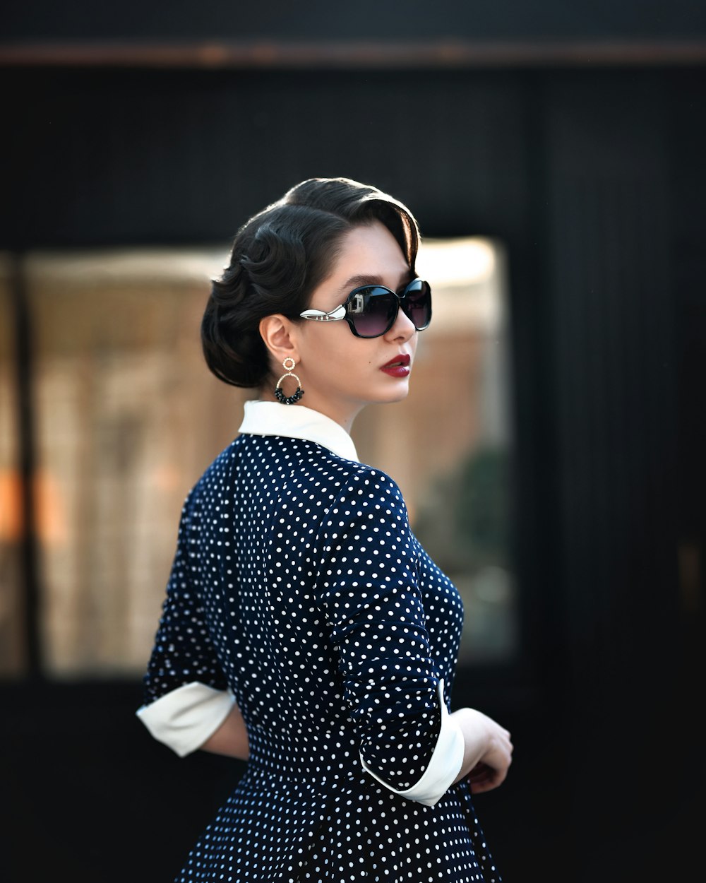 a woman wearing sunglasses and a polka dot dress