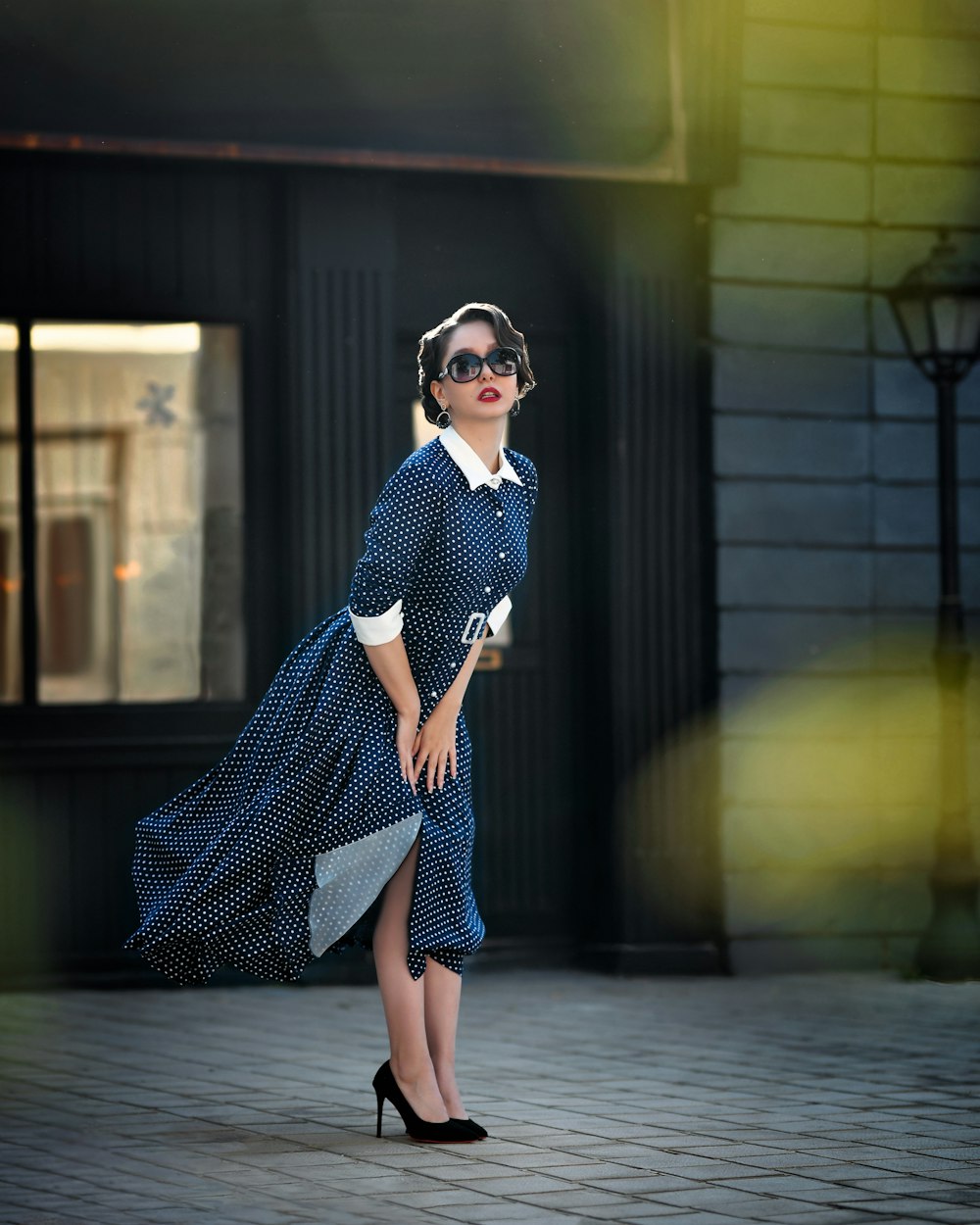 a woman in a blue dress and sunglasses