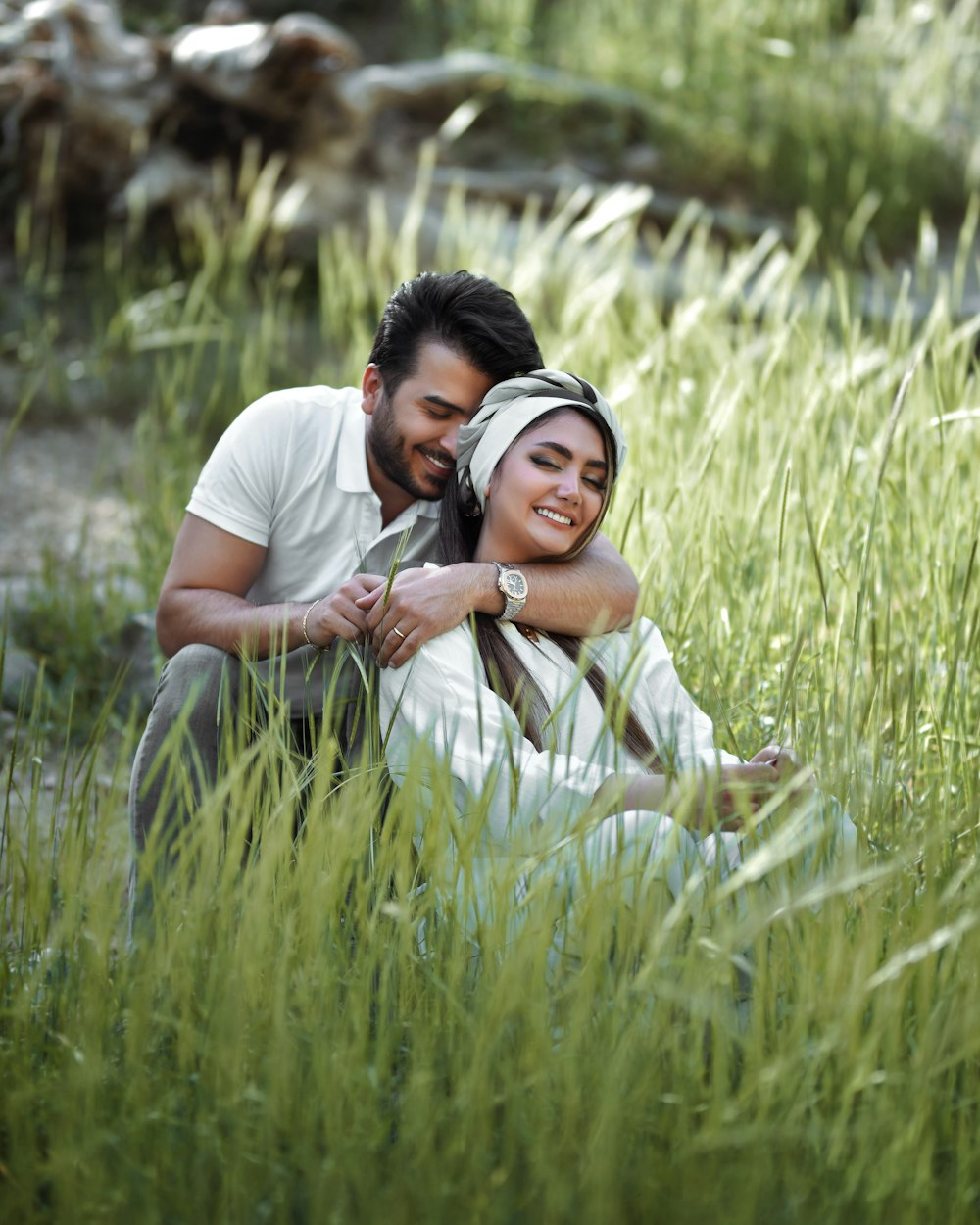 a man and a woman sitting in tall grass