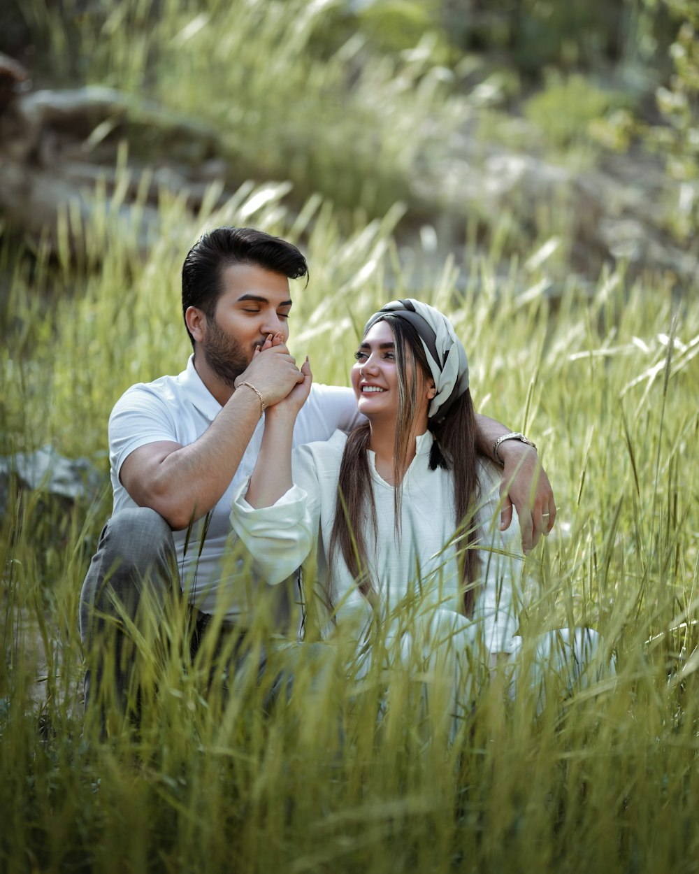 a man and a woman sitting in tall grass