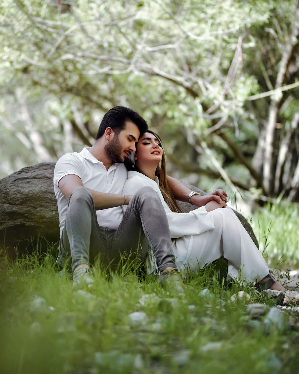 a man and a woman sitting next to each other in the grass