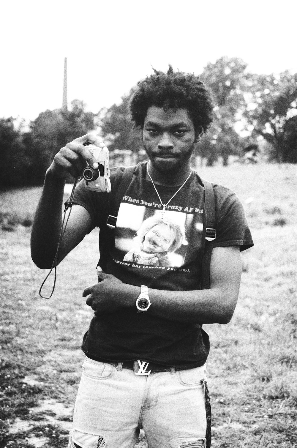 a man standing in a field holding a camera